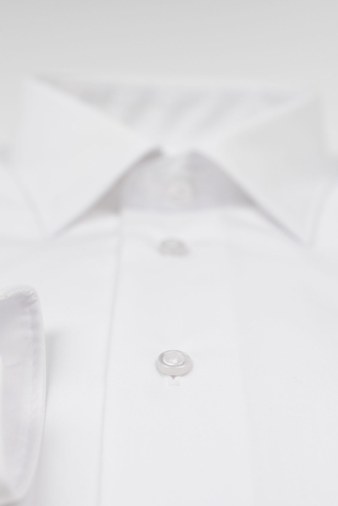 a close up of a button on a white shirt