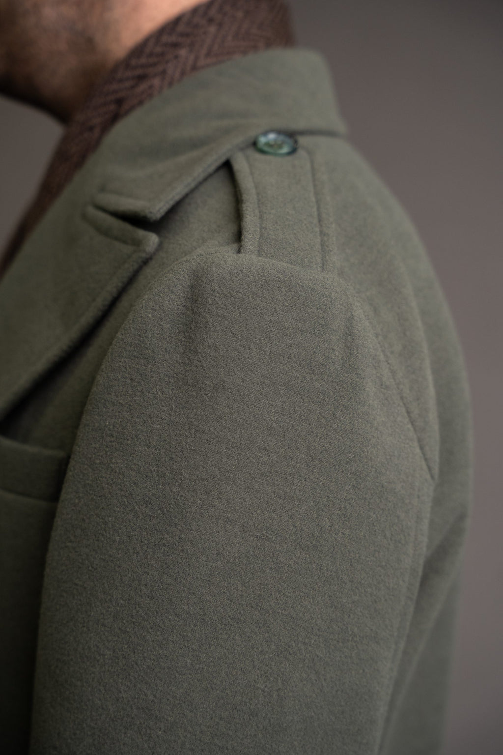 Green military-style men's coat from Quiet Luxury, stylishly designed by Couture for Gentlemen, shown on a model.