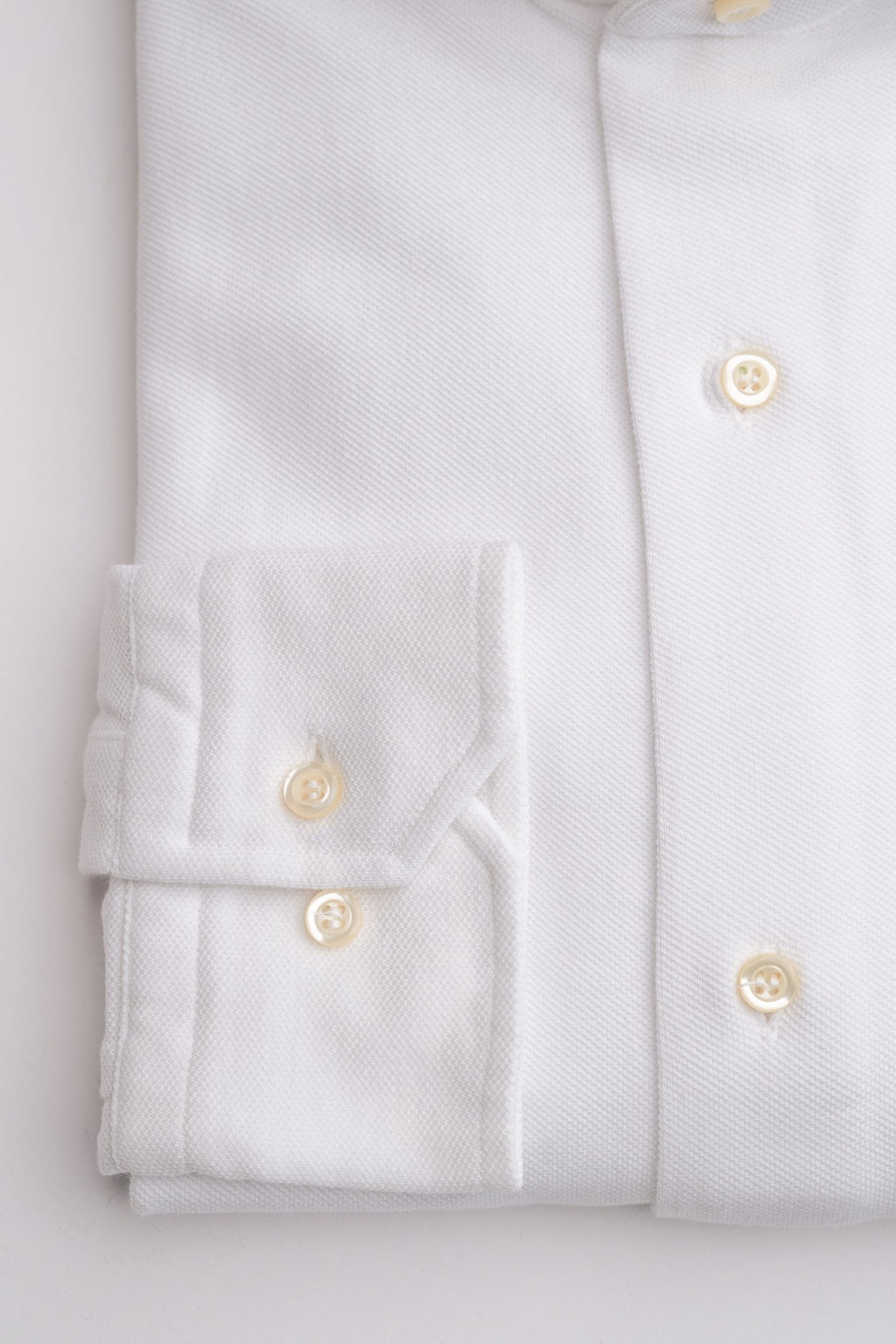 White men's shirt by Sthenford, featuring a classic collar and button-up front, displayed on a hanger.
