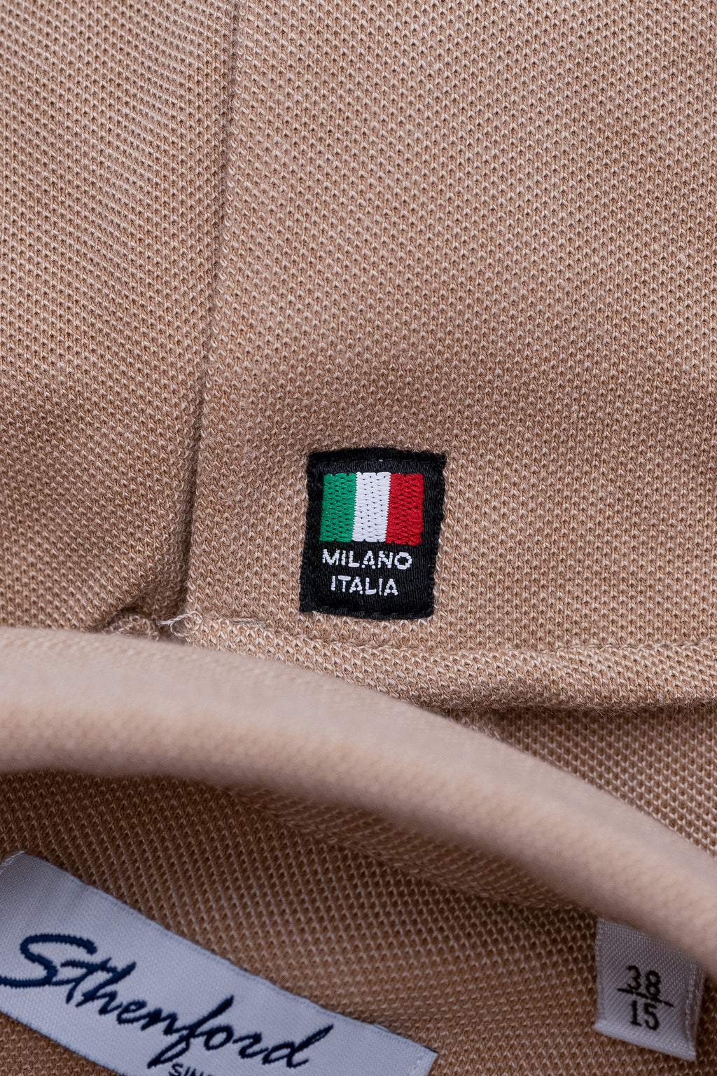 Beige men's shirt from Sthenford CMS02BJS collection, styled on a hanger with a button-up front and classic collar.