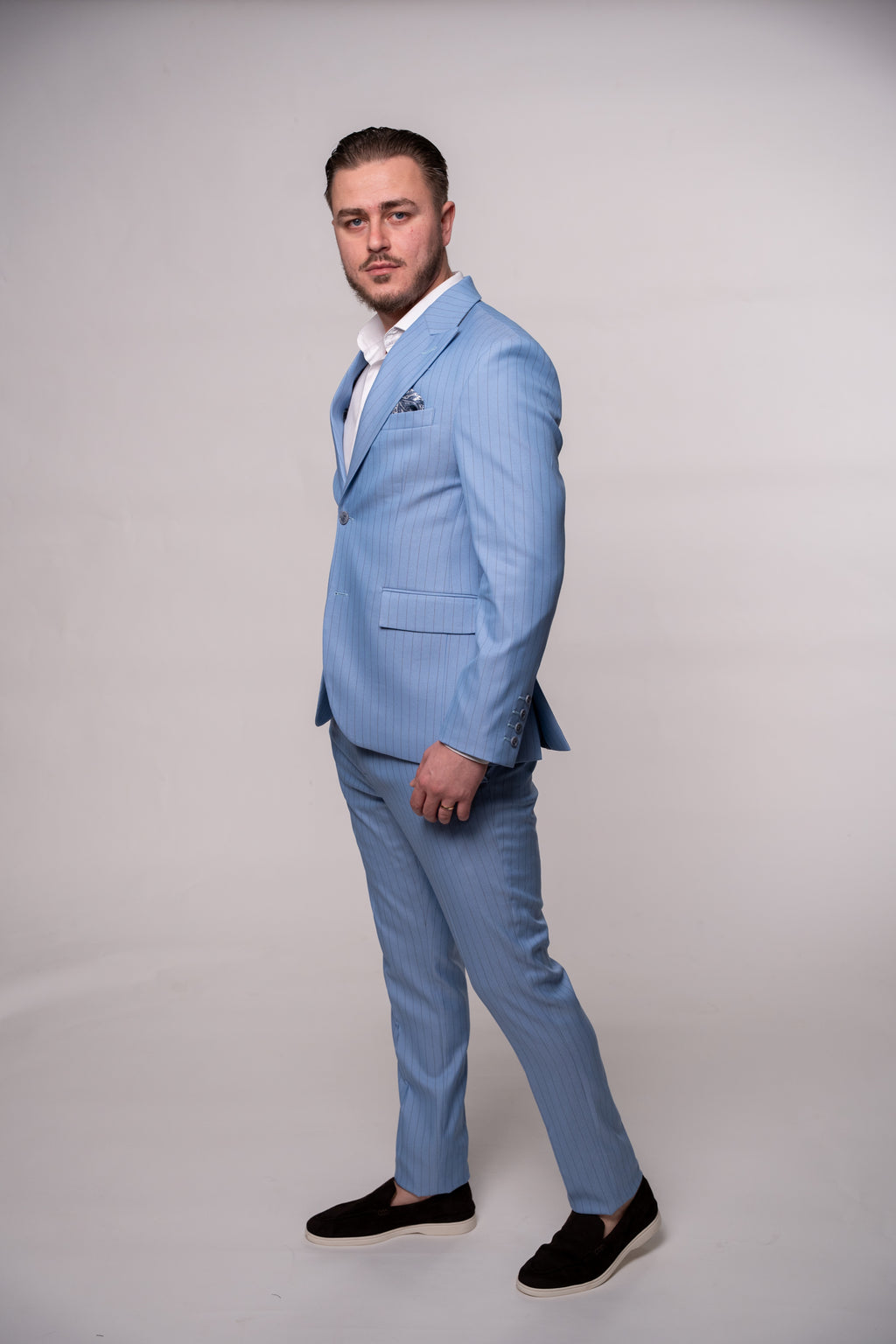 Light blue striped men's suit jacket from CoutureForGentlemen, shown on a hanger with detailed fabric texture.