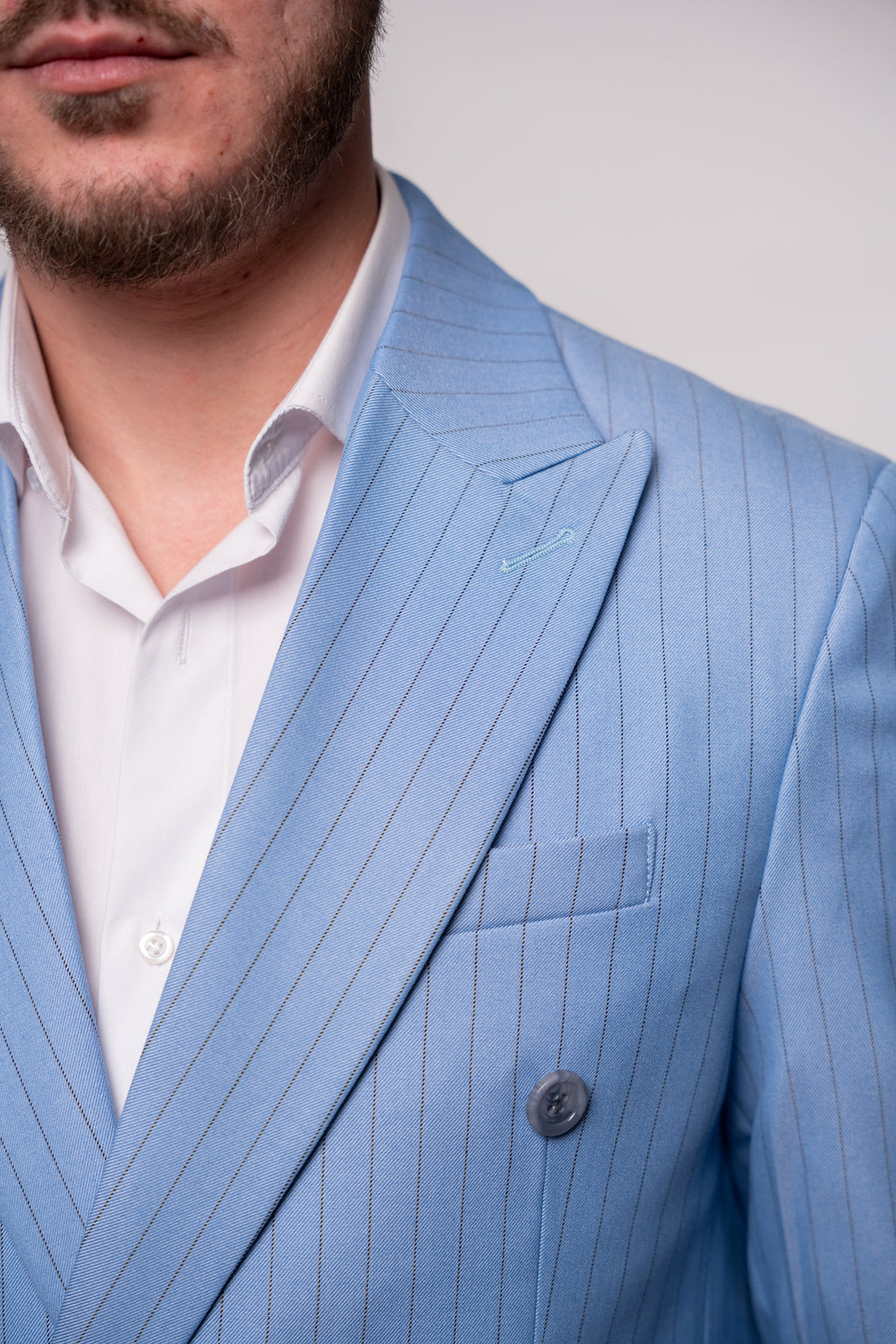 Light blue striped two-row button costume, tailored for men, featuring a classic design with visible buttons on the front.