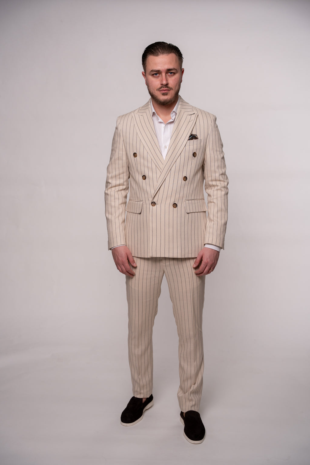 Beige linen men's blazer with two rows of buttons, featuring striped pattern and tailored fit for a classic, sophisticated look.