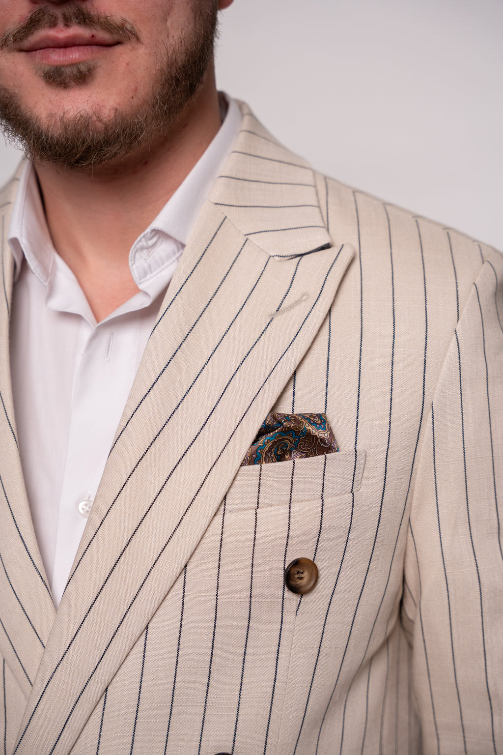 Beige striped men's linen blazer with two rows of buttons, stylish and tailored for a sophisticated look.