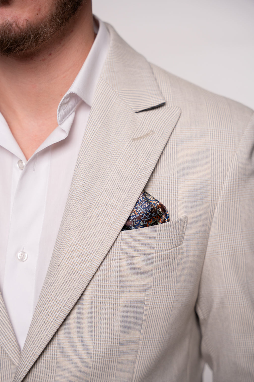 Light beige men's checkered costume jacket with subtle plaid pattern, stylish and tailored for a sophisticated look.