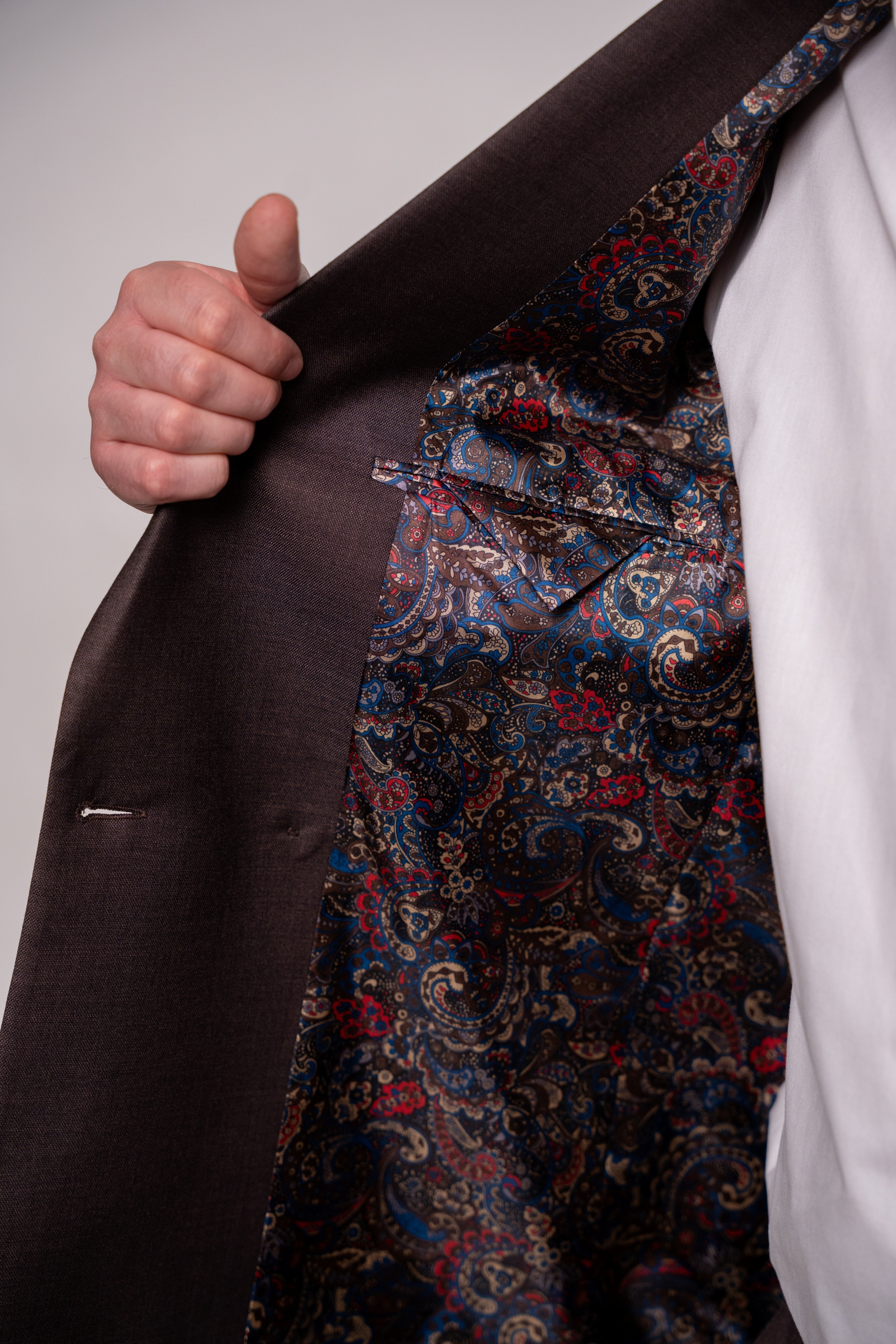 Chocolate brown Napoli double-row men's button costume with visible buttons and tailored fabric, ideal for formal wear.