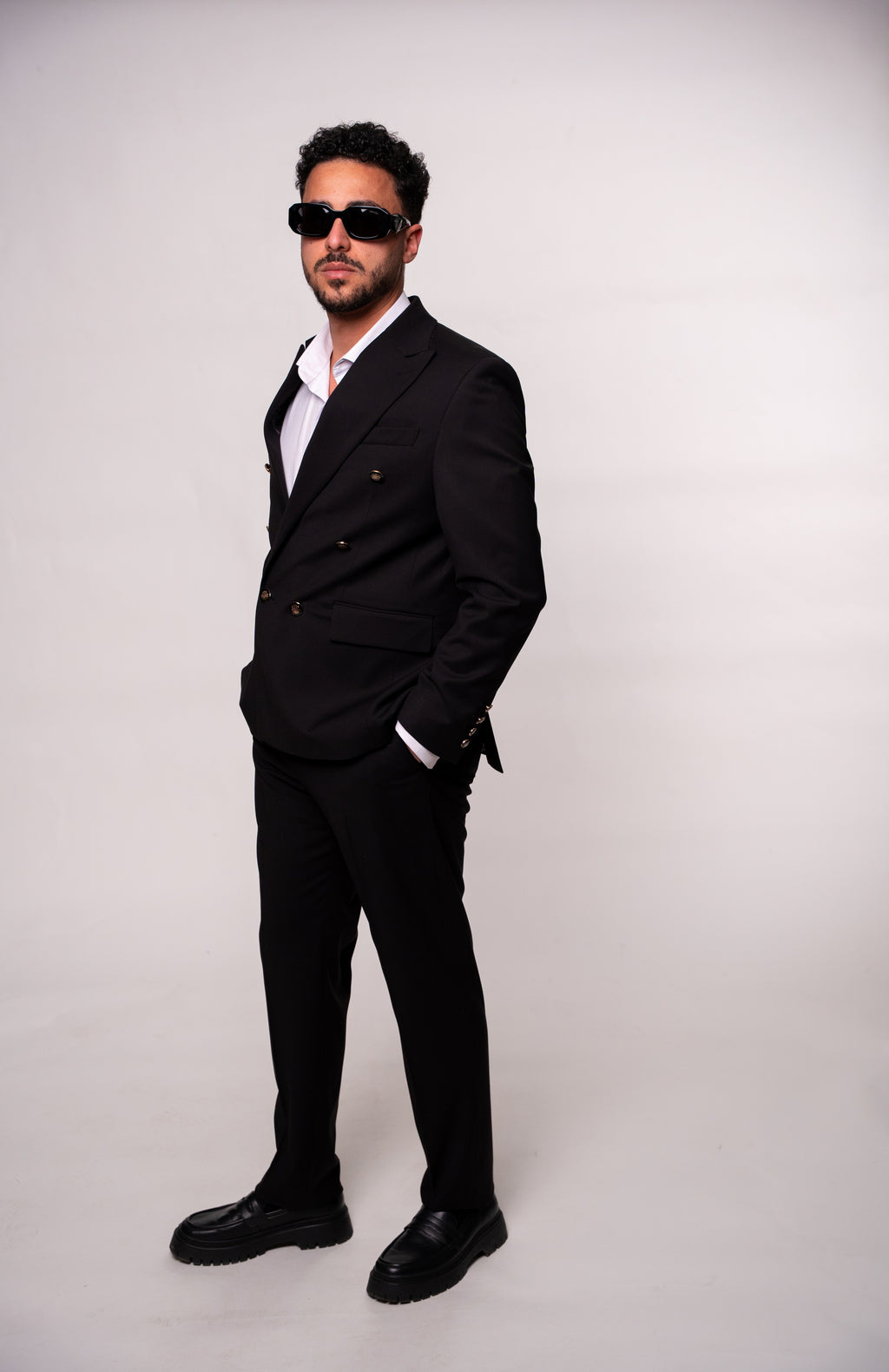 Black men's costume with two rows of buttons, stylish formal suit jacket from Couture for Gentlemen.