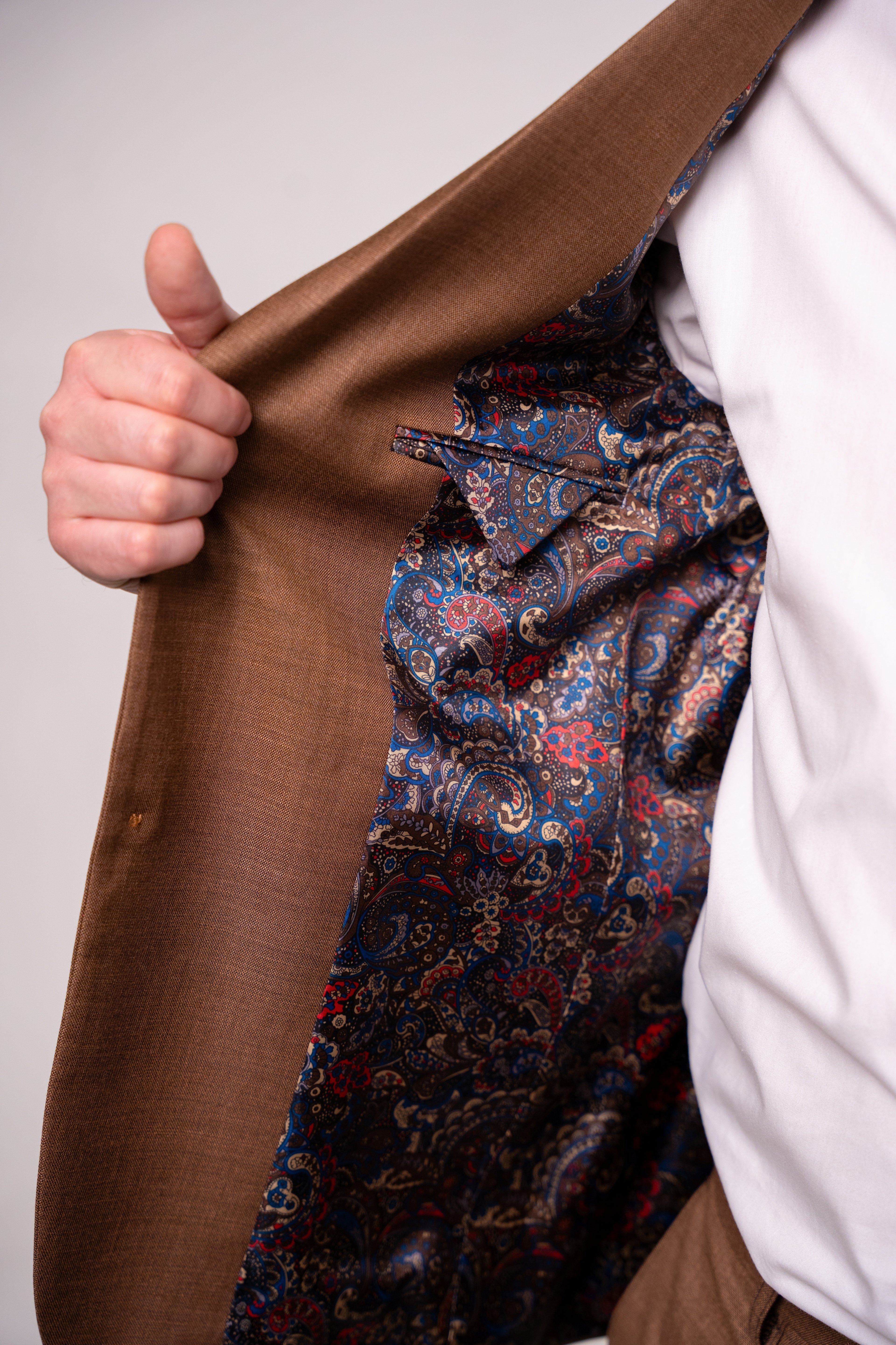 Light brown men's costume by Nisa, featuring a tailored fit and classic design, displayed on a hanger.