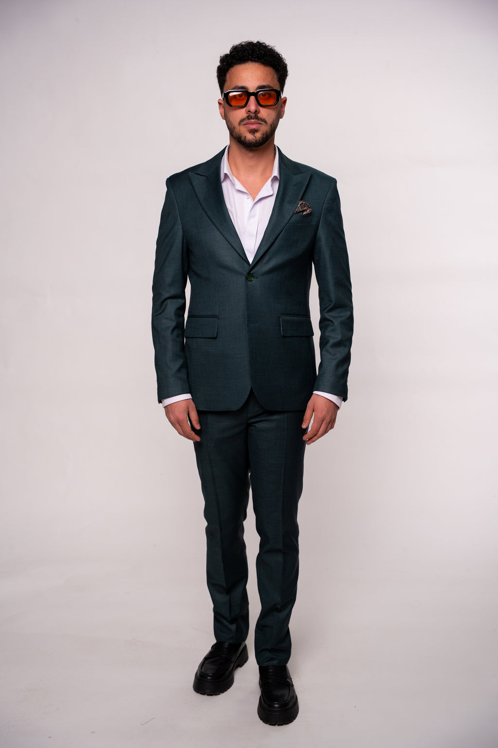 Dark green men's costume jacket with tailored fit, featuring lapels and button details, ideal for formal occasions.
