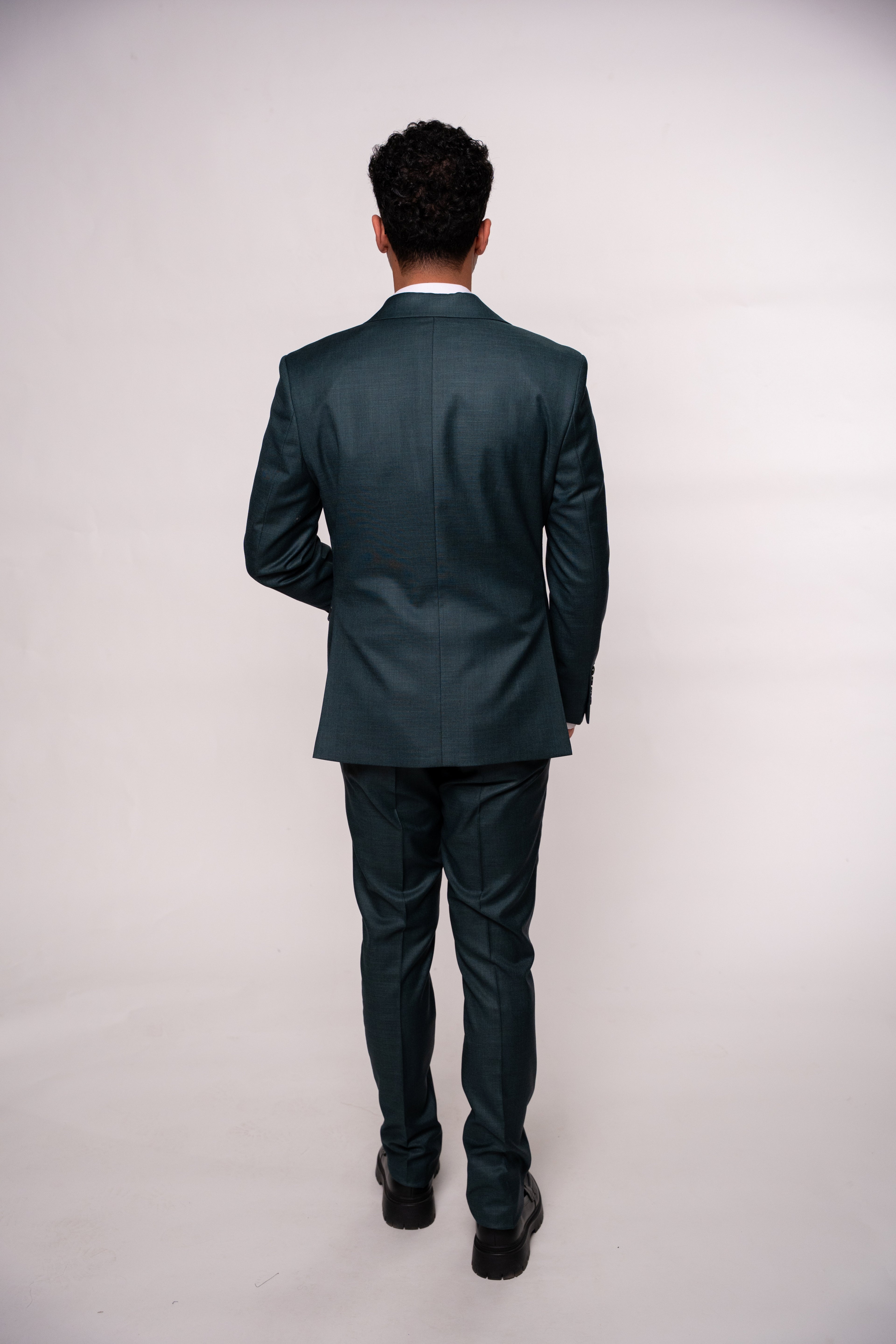 Dark green men's costume jacket by CoutureforGentlemen, tailored fit with button details, shown on a hanger.