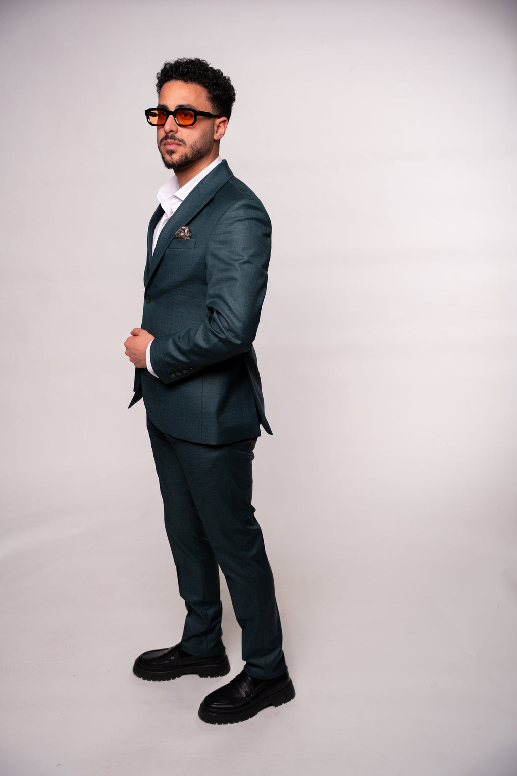 Dark green men's suit by Couture for Gentlemen, tailored fit with lapel collar and button closure, stylish and sophisticated.