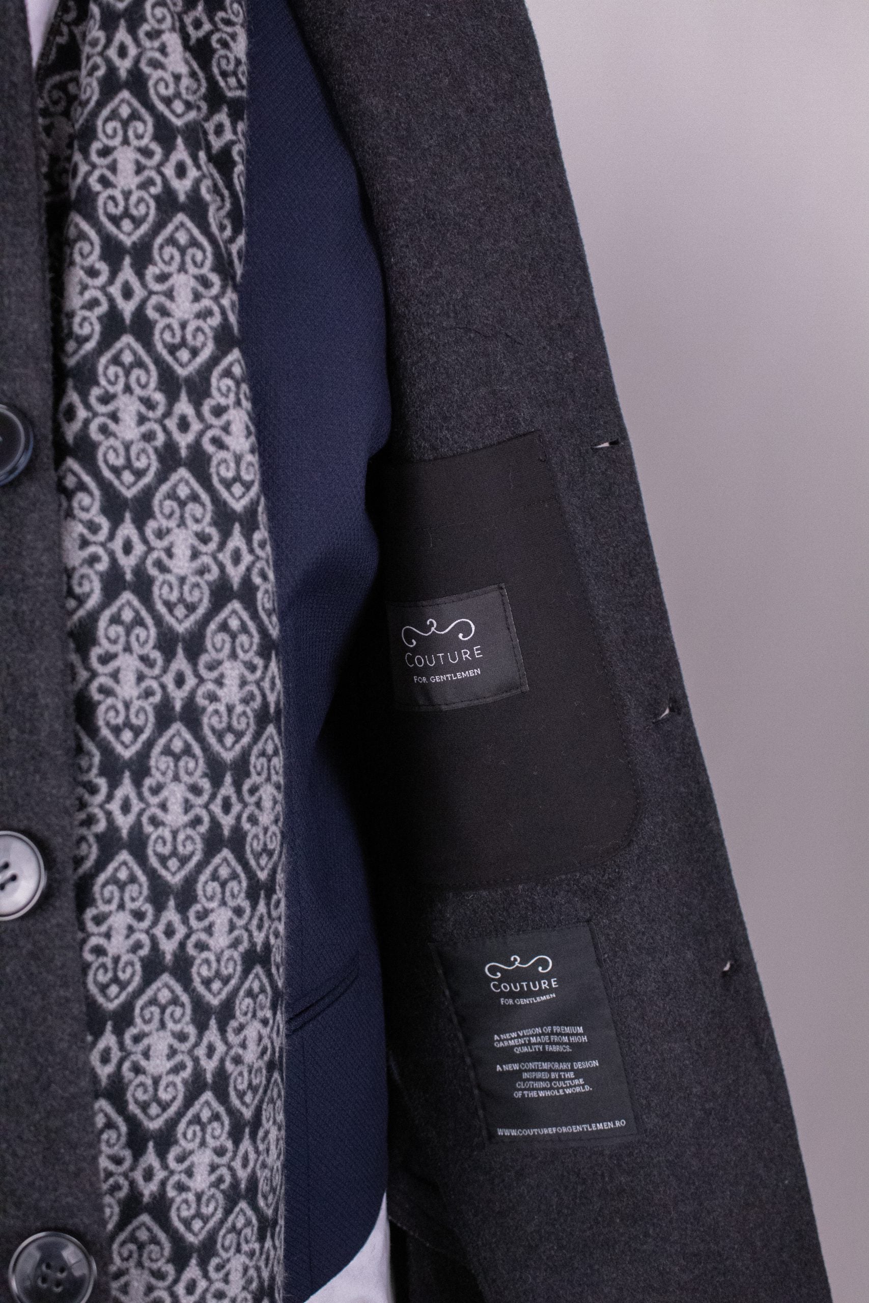 Dark gray men's winter coat, PAR008 by Couture for Gentlemen, shown on a hanger with a focus on the front and textured fabric.