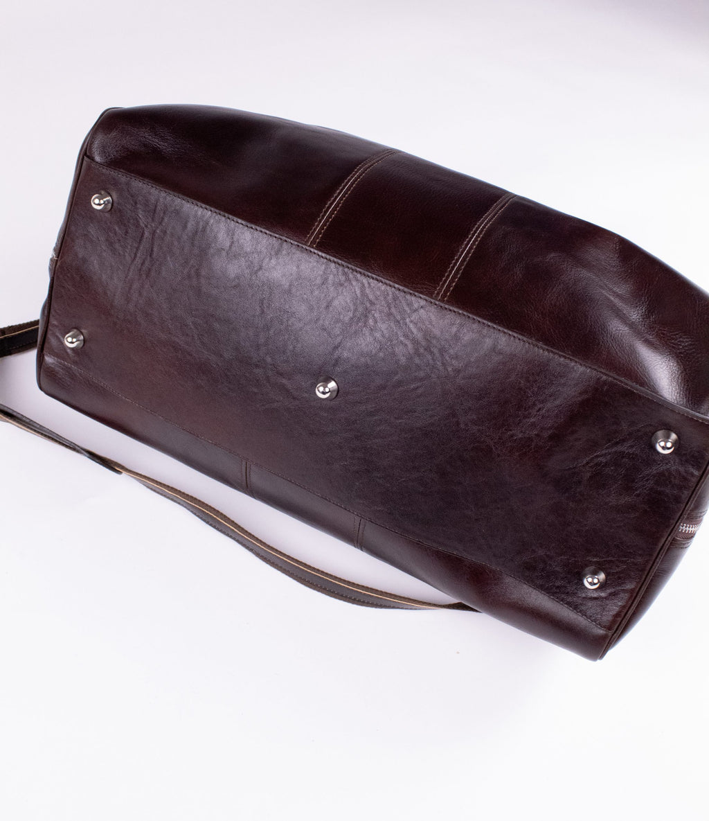 Brown genuine leather travel bag with sturdy handles and spacious interior, ideal for stylish and durable luggage.