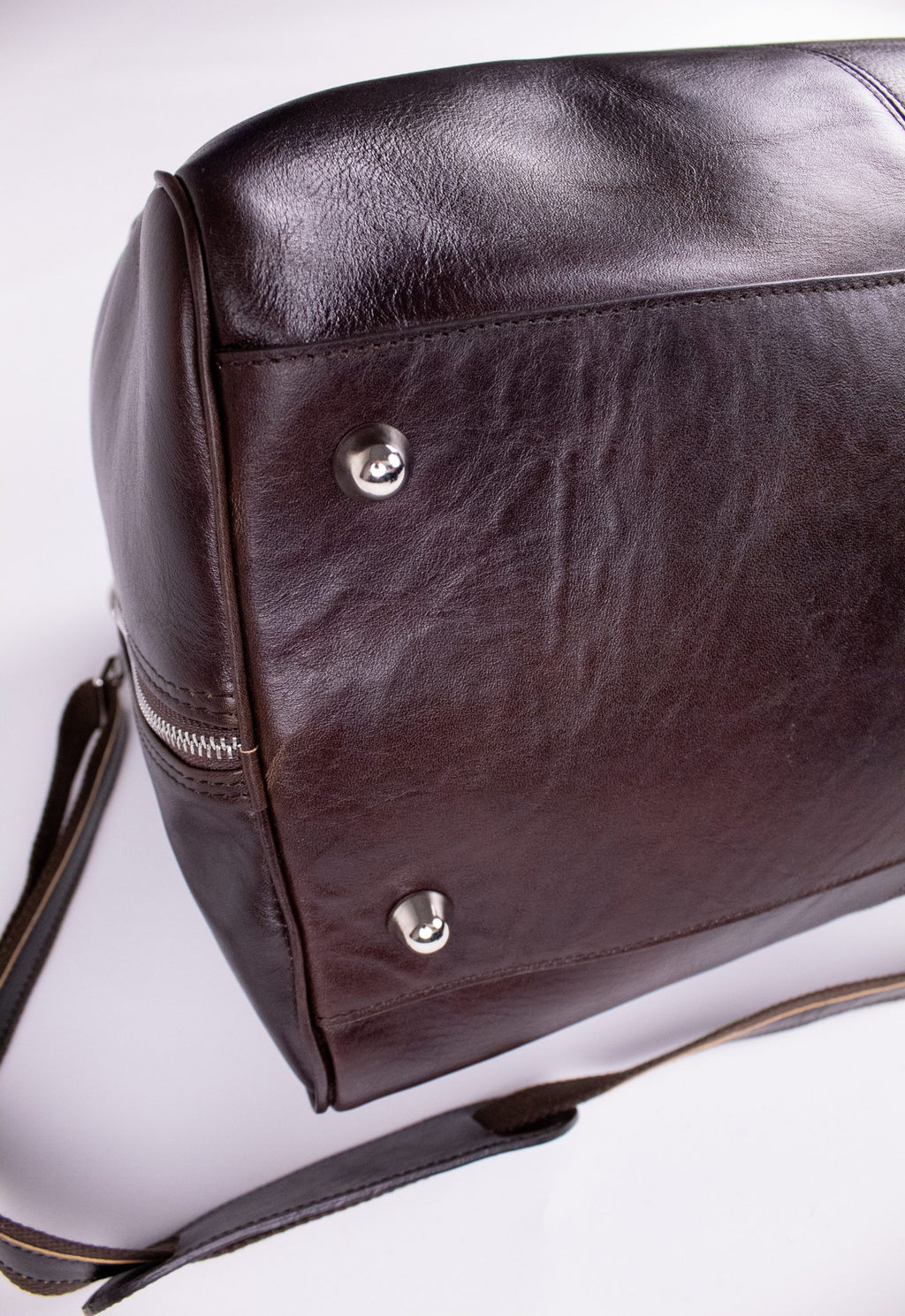 Natural brown leather travel bag with sturdy handles and zipper closure, stylish and spacious for weekend trips.