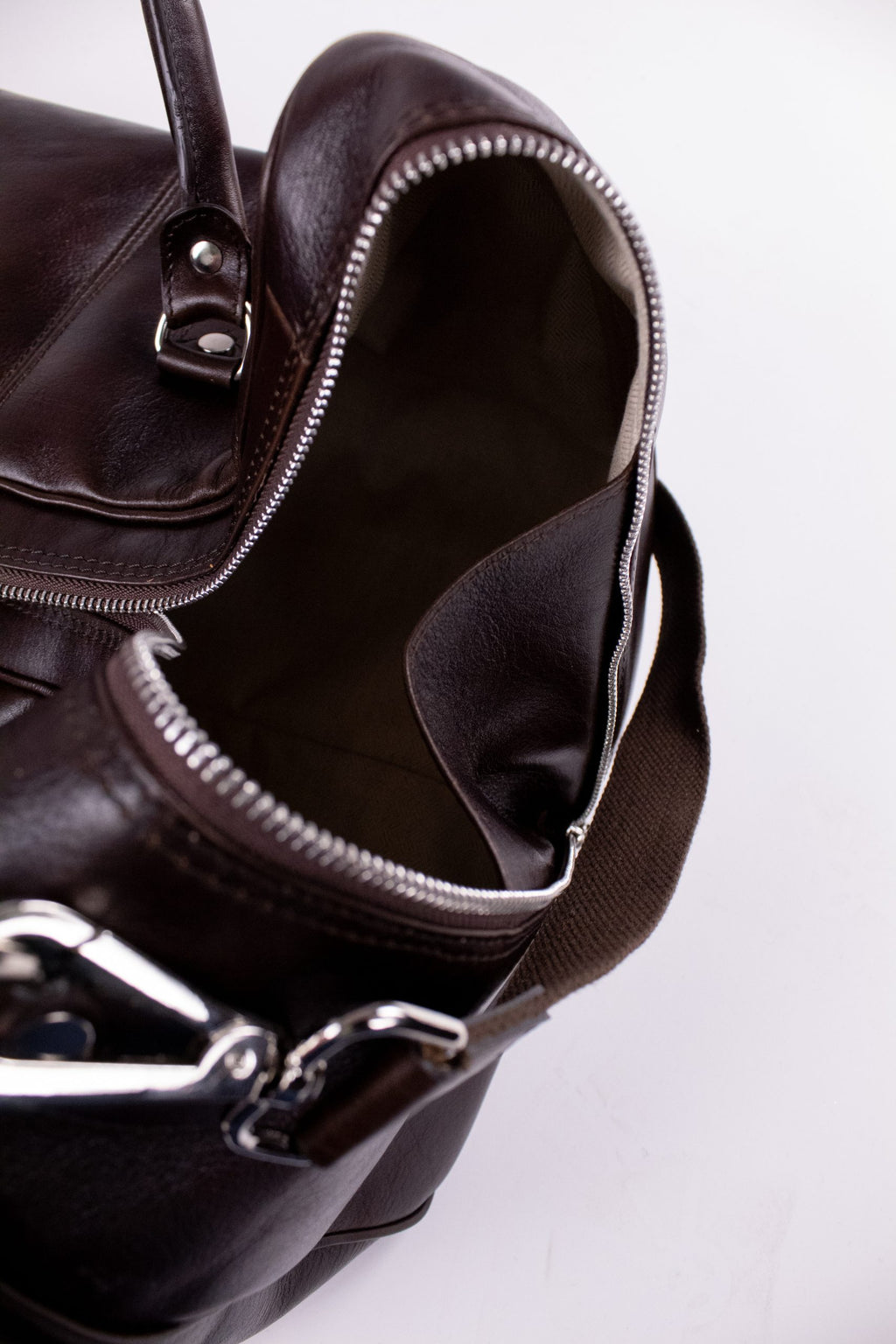 Brown natural leather travel bag with sturdy handles and spacious interior, designed for stylish and durable travel use.