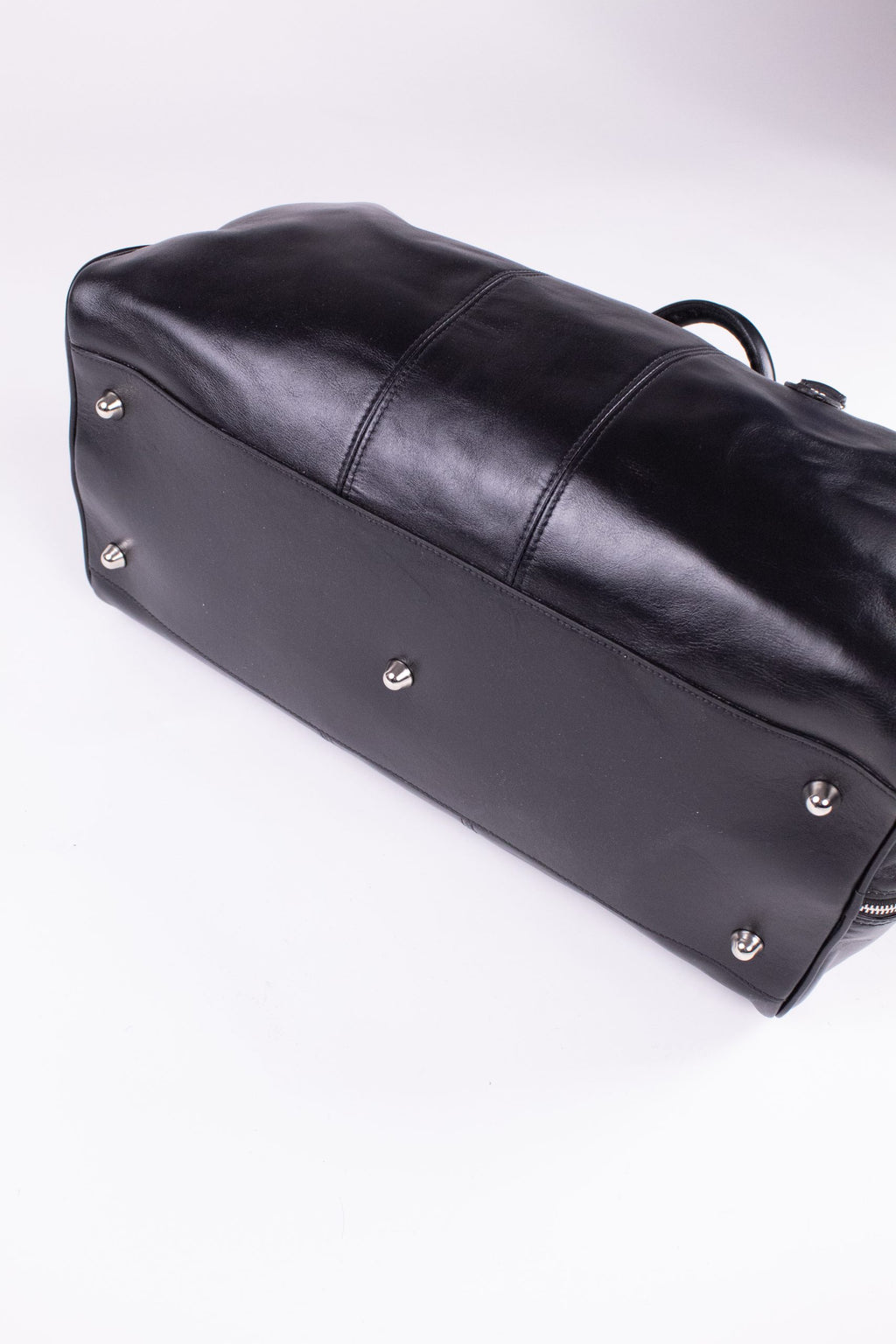 Black genuine leather travel bag with sturdy handles and sleek design, ideal for stylish journeys.