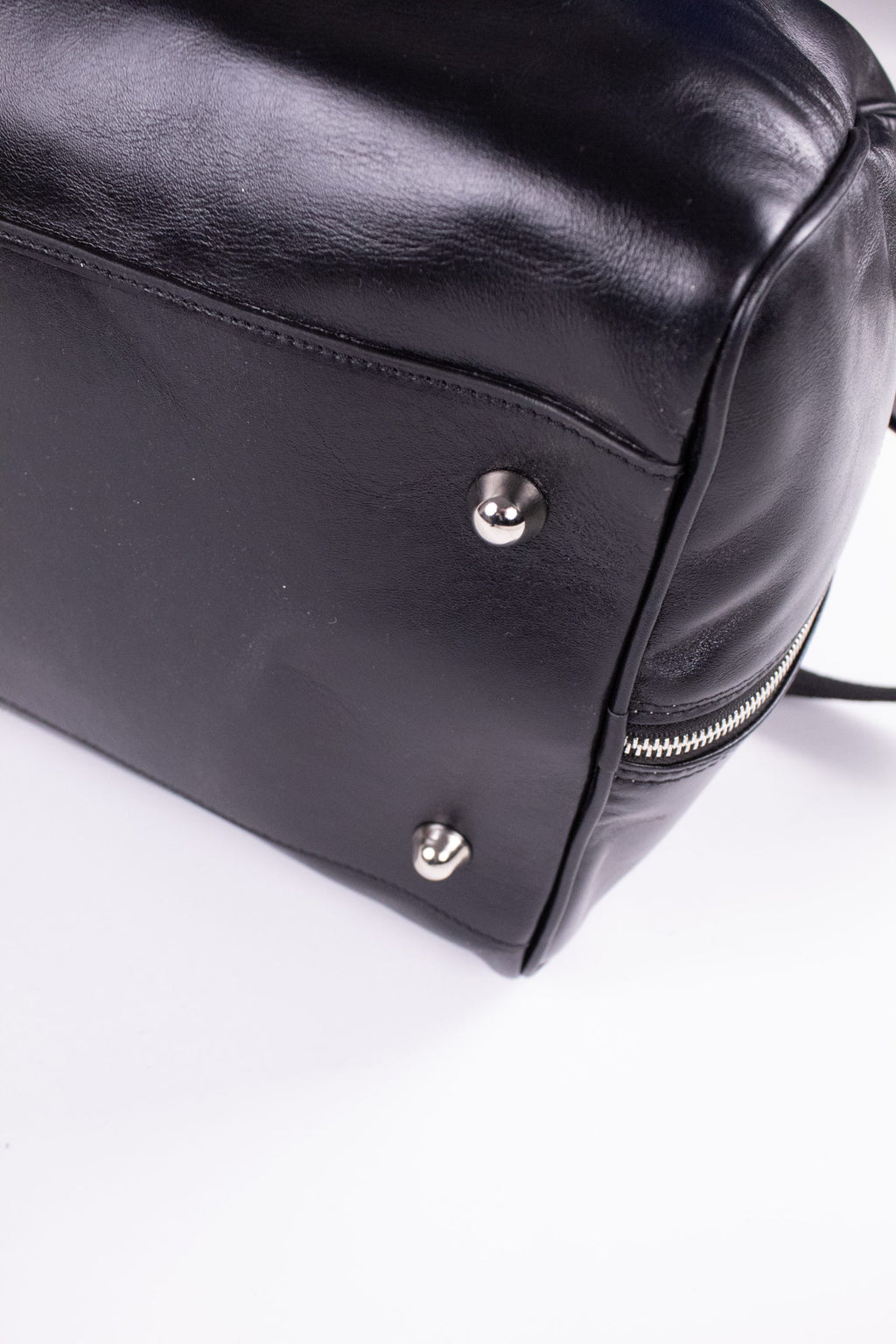 Black genuine leather travel bag with sturdy handles and sleek design, ideal for stylish journeys.