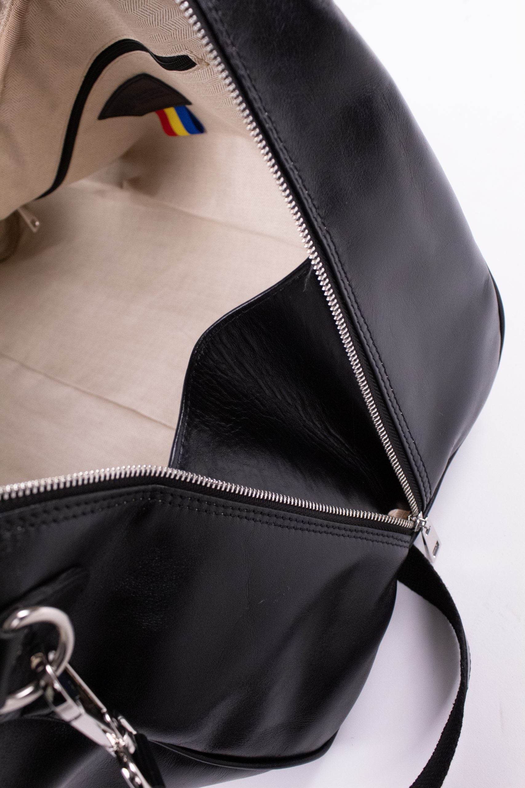 Black genuine leather travel bag with handles and zipper closure, designed for stylish and durable travel accessories.