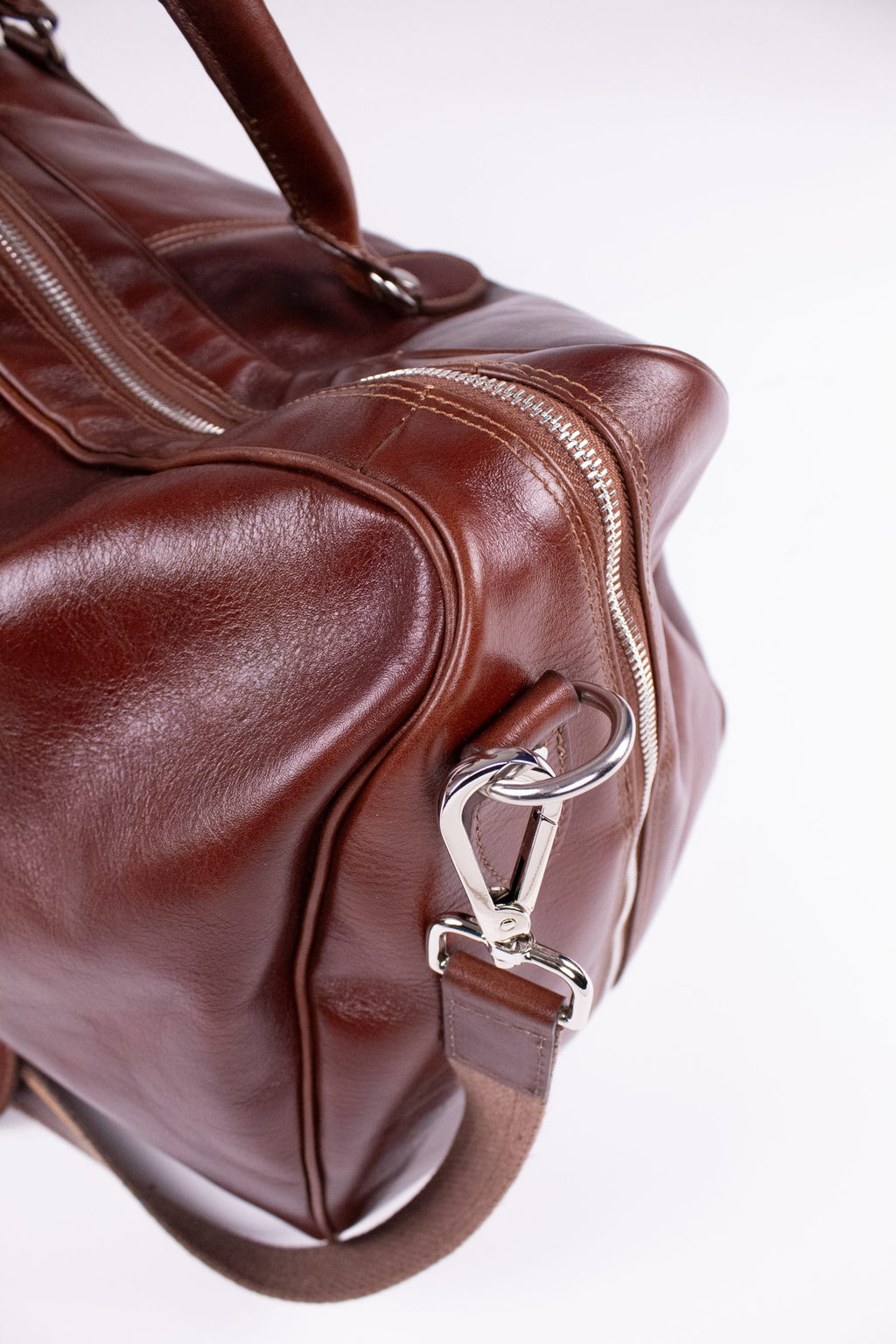 Natural brown leather travel bag with sturdy handles and spacious interior, designed by Couture for Gentlemen.