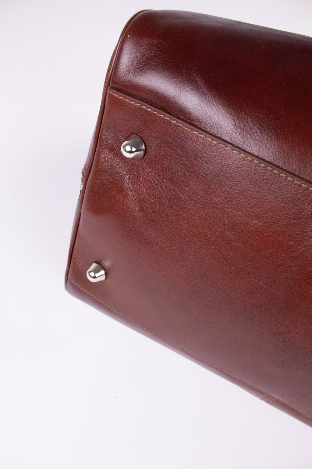 Natural brown leather travel bag with sturdy handles and zipper closure, featuring a sleek design for stylish journeys.