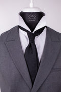 Black paisley silk cravat with intricate pattern, elegant accessory for formal men's fashion.