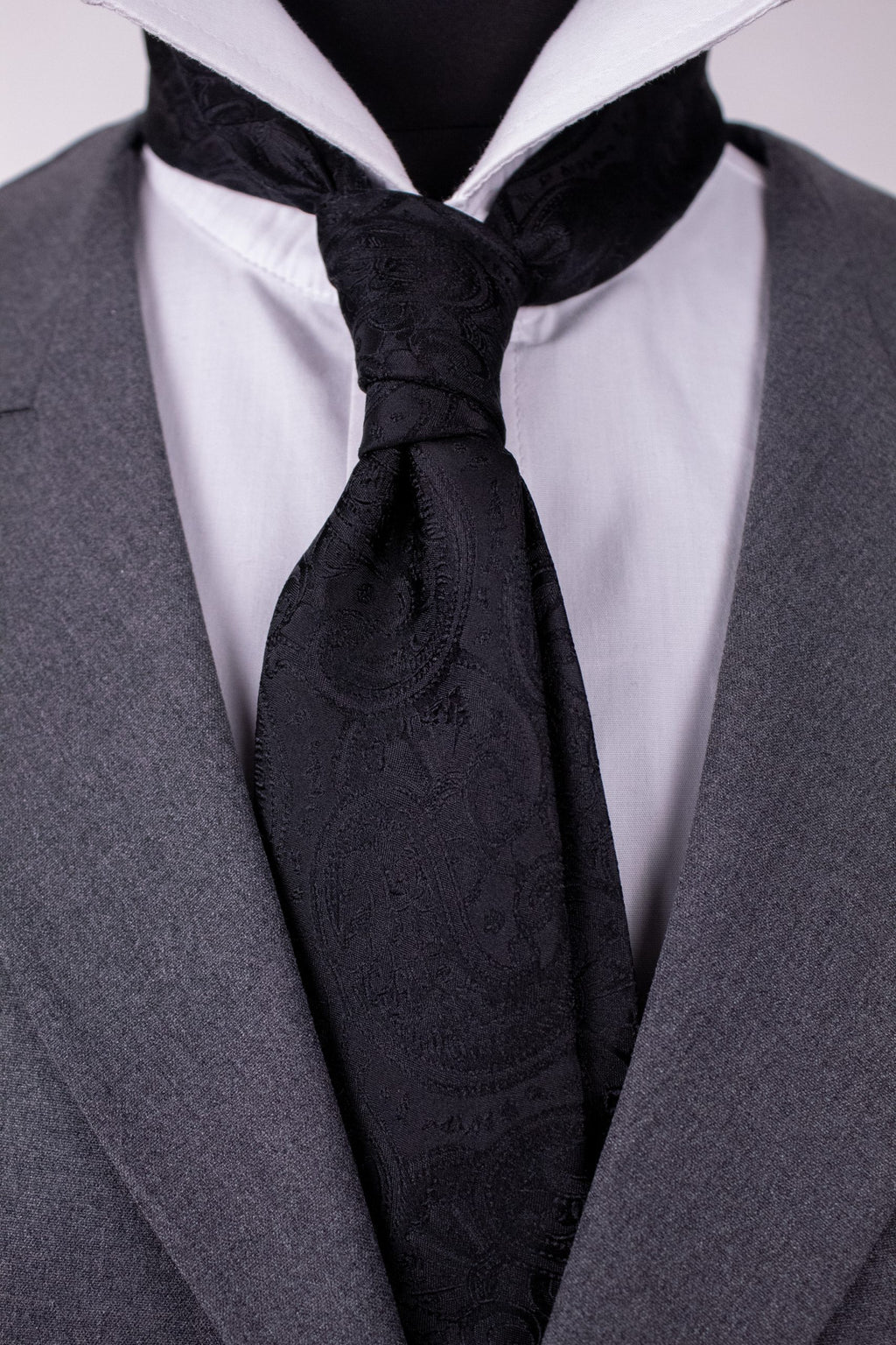 Black paisley silk cravat with intricate patterns, stylish accessory for formal wear, crafted by Couture for Gentlemen.