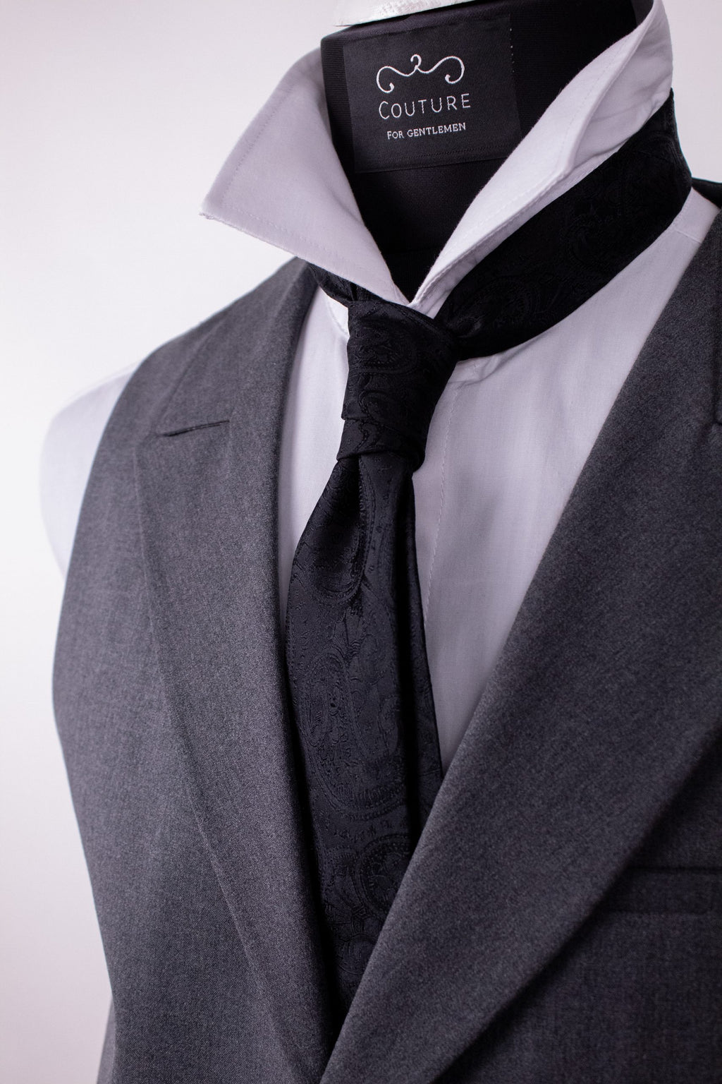 Black paisley silk cravat showcasing intricate patterns and luxurious fabric, perfect for elegant men's formalwear.