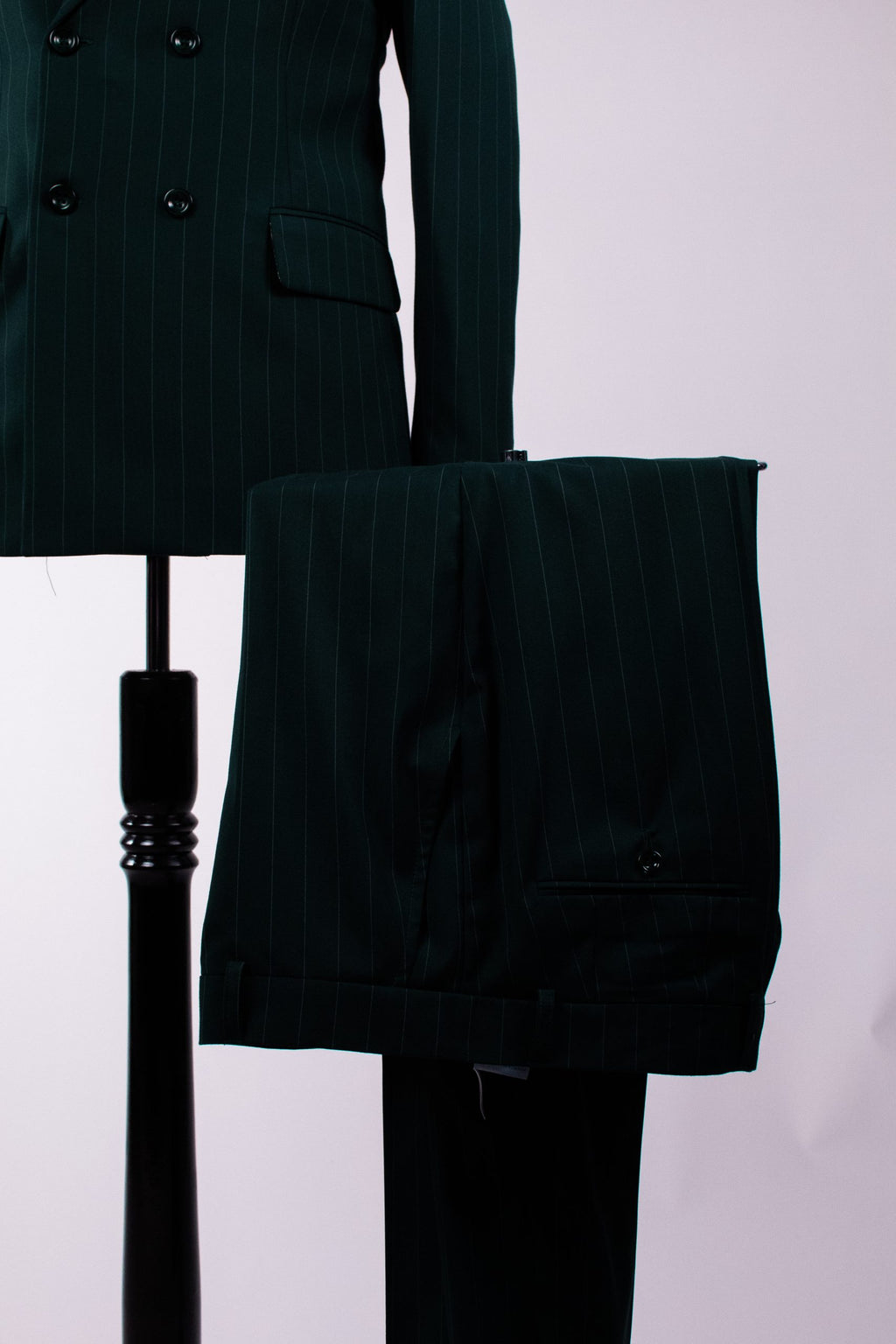 Dark green men's costume with double-row buttons and tailored fit, featuring vertical stripes, from Couture for Gentlemen.