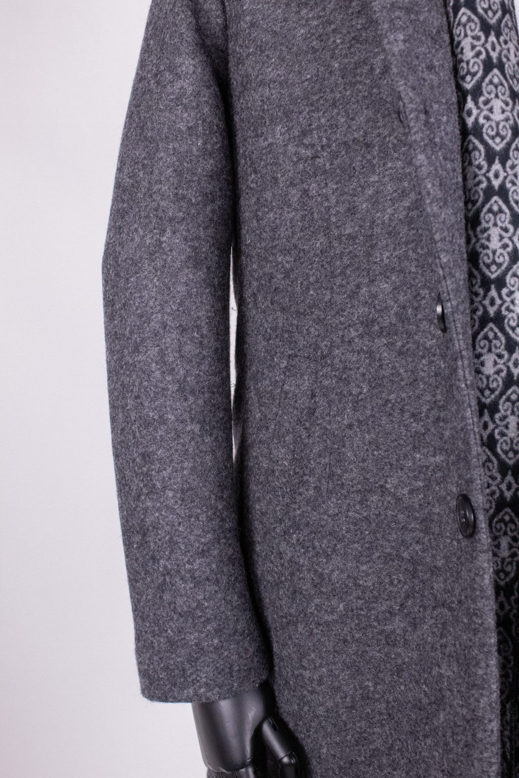 Dark gray men's trench coat PAR008 by Couture for Gentlemen, shown hanging on a wooden hanger.